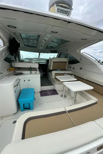  Yacht Photos Pics 2010 Sea Ray 470 Sundancer interior with seating, tables, and kitchenette under a cloudy sky.