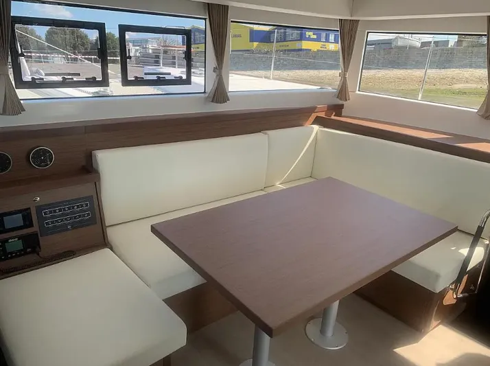 Yacht Photos Pics Interior of 2019 Lagoon 40 catamaran with cream seating and wooden table.