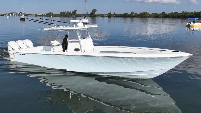  Yacht Photos Pics 2021 Contender 39 ST boat on calm water, featuring triple engines and sleek design.