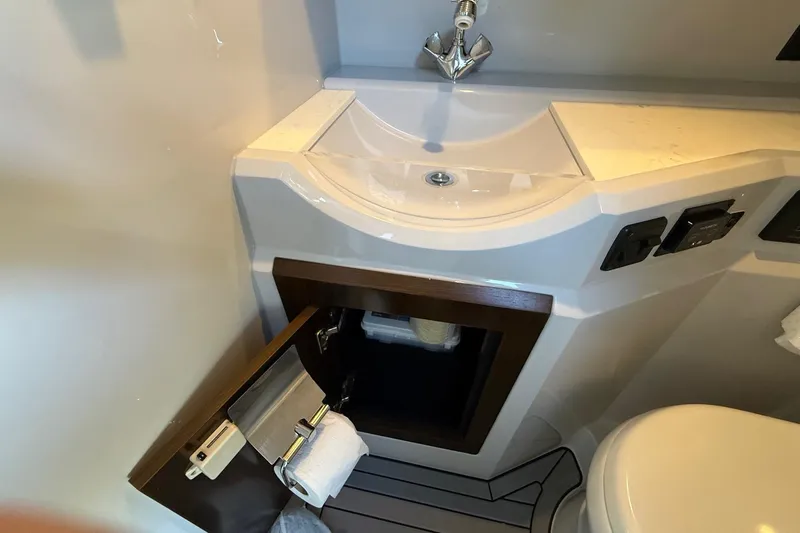  Yacht Photos Pics 2021 Cruisers Yachts 338 CX South Beach Bow Rider bathroom with sink and storage cabinet.