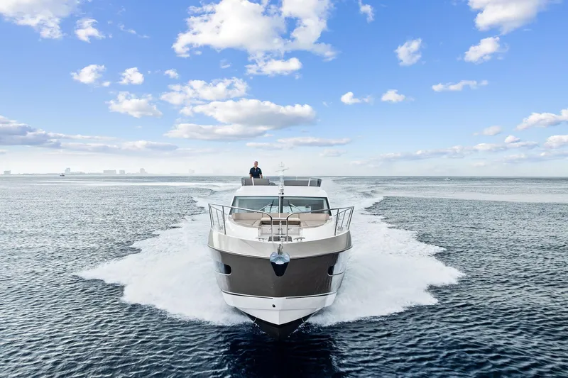 Miller Time Yacht Photos Pics 2021 Sunseeker Manhattan 52 yacht cruising on open water under a blue sky.