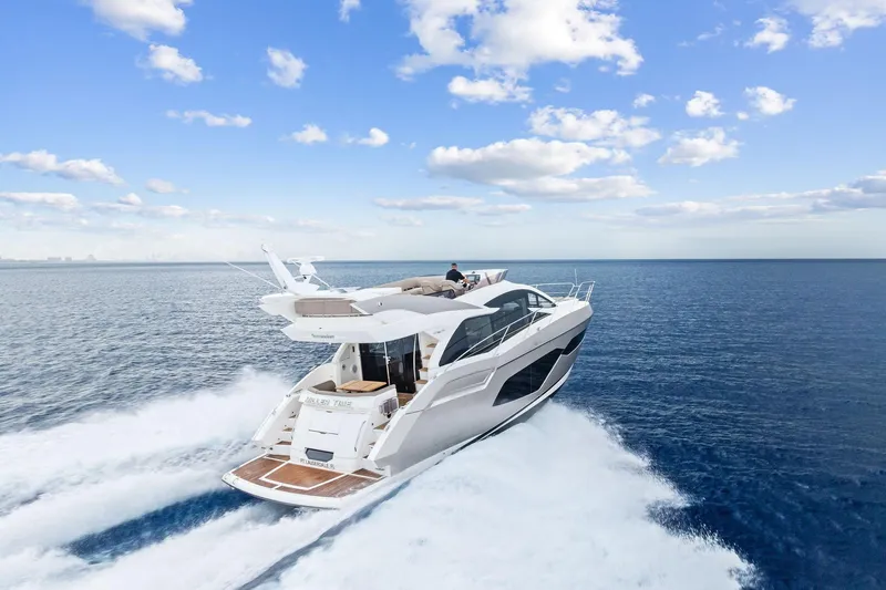 Miller Time Yacht Photos Pics 2021 Sunseeker Manhattan 52 yacht cruising on open sea under blue sky.