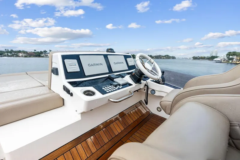 Miller Time Yacht Photos Pics 2021 Sunseeker Manhattan 52 yacht helm with Garmin navigation, luxurious seating, and waterfront view.