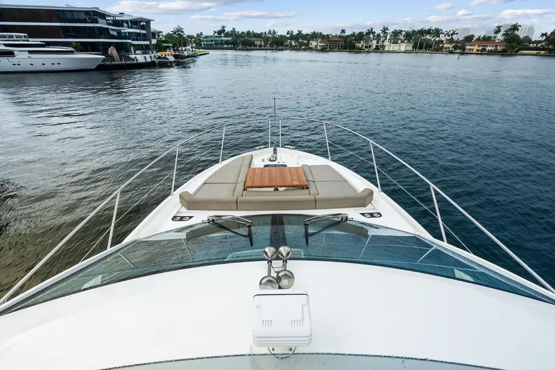 Miller Time Yacht Photos Pics 2021 Sunseeker Manhattan 52 yacht on calm water, featuring luxurious deck seating.