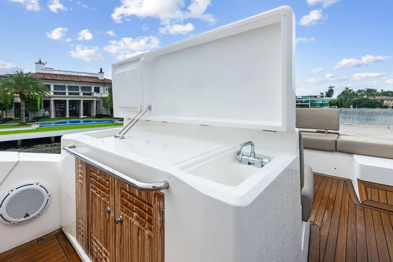 Miller Time Yacht Photos Pics Sunseeker Manhattan 52 yacht deck with sink, wooden cabinetry, and luxurious seating, 2021 model.