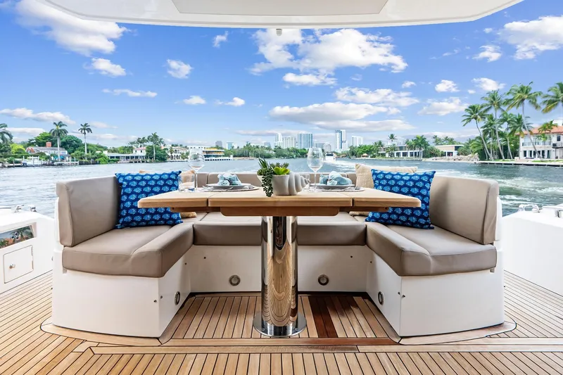 Miller Time Yacht Photos Pics Luxurious Sunseeker Manhattan 52 yacht deck with elegant seating and scenic waterfront view.