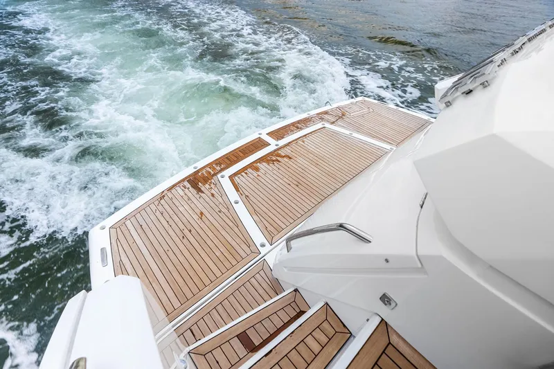 Miller Time Yacht Photos Pics Sunseeker Manhattan 52 yacht's teak deck, 2021 model, with ocean waves in the background.