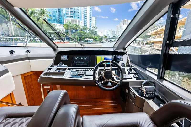 Miller Time Yacht Photos Pics Luxurious 2021 Sunseeker Manhattan 52 yacht cockpit with modern navigation controls and waterfront view.