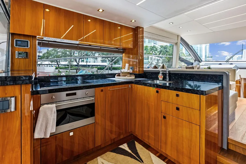 Miller Time Yacht Photos Pics Luxurious kitchen interior of 2021 Sunseeker Manhattan 52 yacht with sleek wood cabinetry.