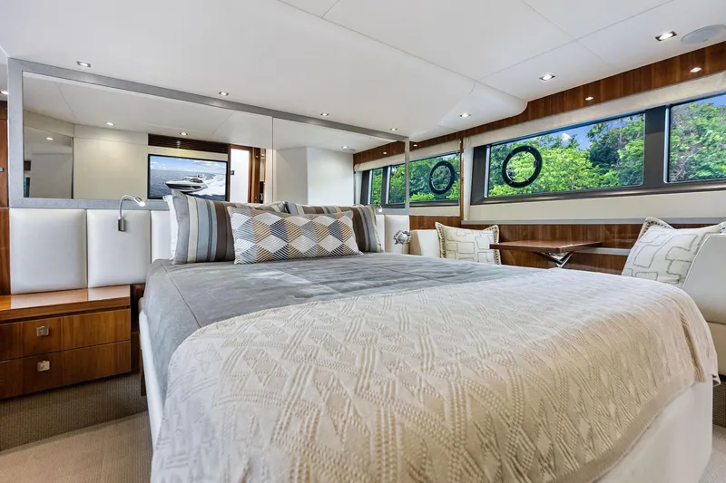 Miller Time Yacht Photos Pics Luxurious bedroom interior of 2021 Sunseeker Manhattan 52 yacht with elegant decor and large windows.