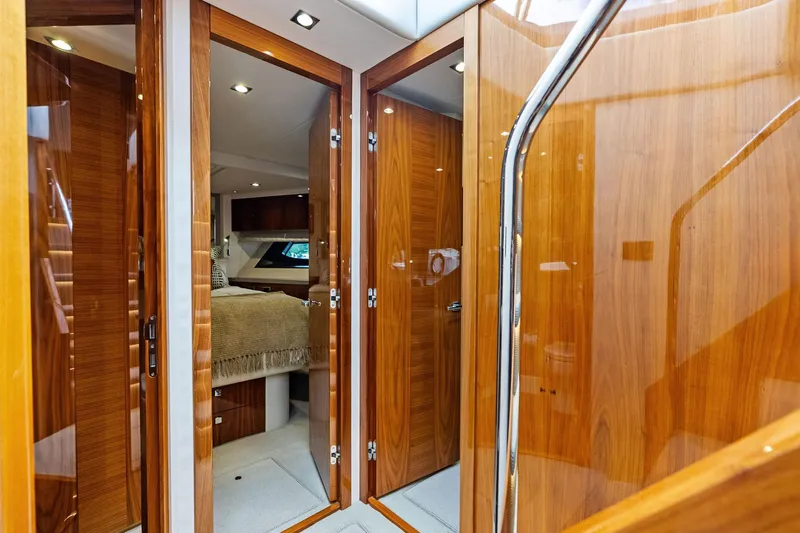 Miller Time Yacht Photos Pics Luxurious interior of 2021 Sunseeker Manhattan 52 yacht with wooden finishes and cozy bedroom.