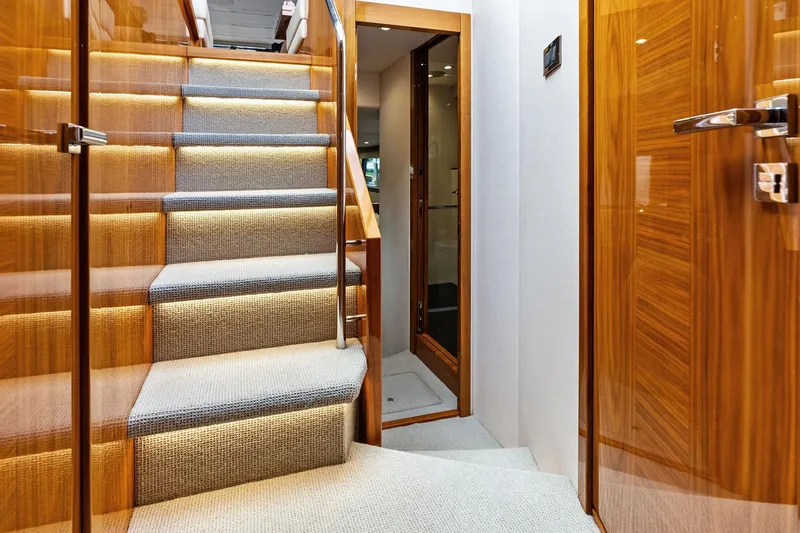 Miller Time Yacht Photos Pics Luxurious interior staircase of 2021 Sunseeker Manhattan 52 yacht with elegant wood finish.