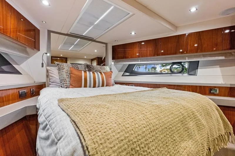 Miller Time Yacht Photos Pics Luxurious bedroom interior of 2021 Sunseeker Manhattan 52 yacht with elegant wood finishes.