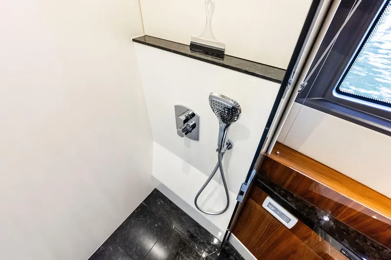 Miller Time Yacht Photos Pics Luxury shower area in 2021 Sunseeker Manhattan 52 yacht, featuring modern fixtures and window view.