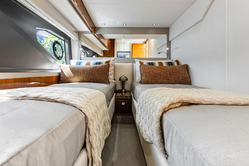 Miller Time Yacht Photos Pics Luxurious twin cabin interior of 2021 Sunseeker Manhattan 52 yacht, featuring elegant bedding and decor.