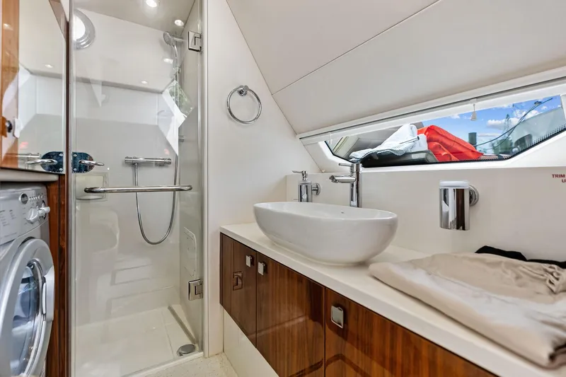 Miller Time Yacht Photos Pics Luxurious bathroom in 2021 Sunseeker Manhattan 52 yacht with modern fixtures and washing machine.
