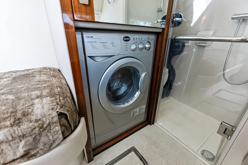 Miller Time Yacht Photos Pics Washing machine inside 2021 Sunseeker Manhattan 52 yacht bathroom, featuring modern design.