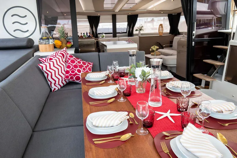 Vienna Yacht Photos Pics Luxurious dining setup on 2022 Fountaine Pajot Catamaran Aura 51, featuring elegant tableware and decor.