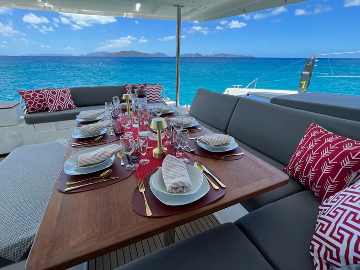Vienna Yacht Photos Pics Luxurious dining setup on 2022 Fountaine Pajot Catamaran Aura 51, overlooking serene ocean view.
