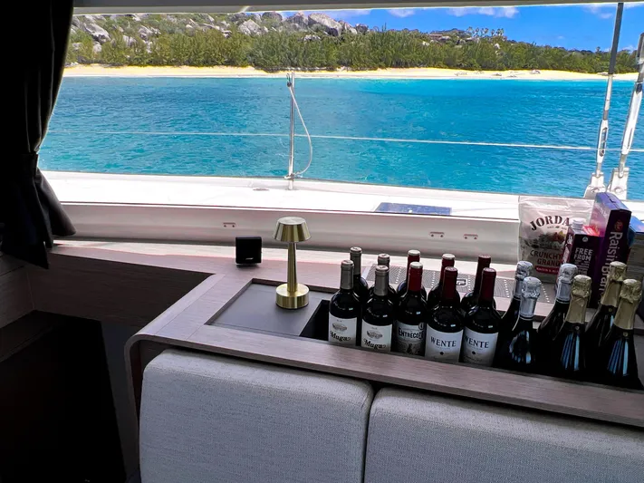 Vienna Yacht Photos Pics Luxury interior of 2022 Fountaine Pajot Catamaran Aura 51 with wine selection, ocean view.