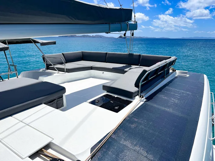 Vienna Yacht Photos Pics 2022 Fountaine Pajot Catamaran Aura 51 on tranquil blue sea, featuring spacious deck seating.