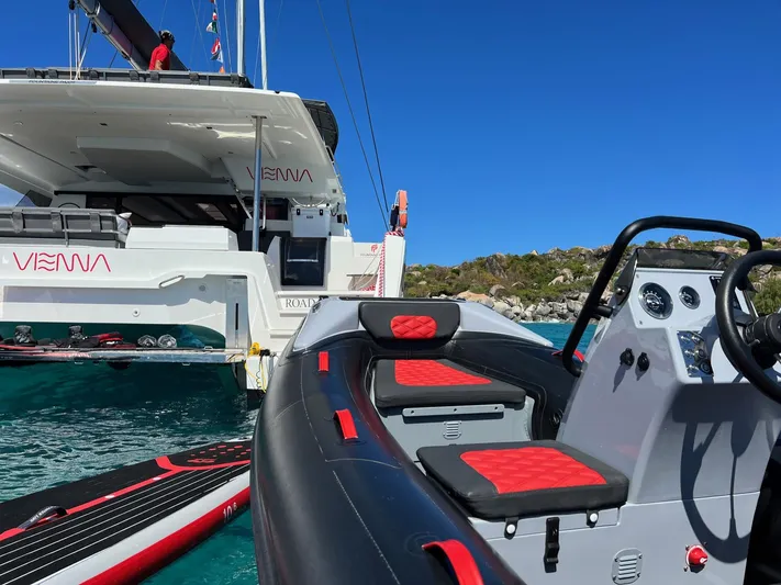 Vienna Yacht Photos Pics Fountaine Pajot Catamaran Aura 51, 2022, docked with inflatable boat in clear blue water.