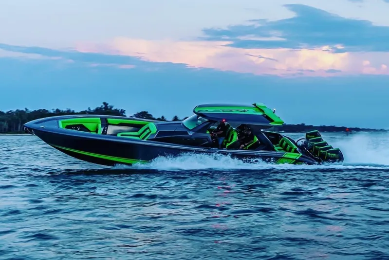 Crypto Excepted! Yacht Photos Pics 2023 Adrenaline 47 speedboat cruising on water at sunset, featuring vibrant green accents.