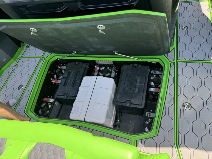 Crypto Excepted! Yacht Photos Pics Open battery compartment of 2023 Adrenaline 47 boat with green trim and hexagonal flooring.
