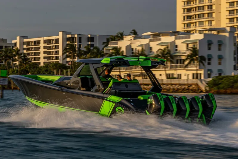 Crypto Excepted! Yacht Photos Pics 2023 Adrenaline 47 speedboat cruising near modern waterfront buildings.