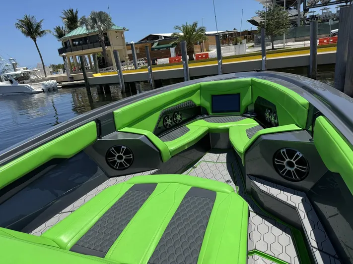 Crypto Excepted! Yacht Photos Pics 2023 Adrenaline 47 boat interior with vibrant green seating and modern design at a marina.