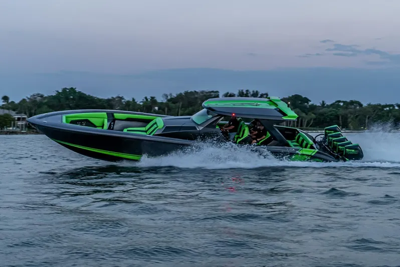 Crypto Excepted! Yacht Photos Pics 2023 Adrenaline 47 speedboat cruising on water at dusk, featuring vibrant green accents.