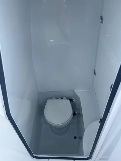 Yacht Photos Pics 2023 Contender 25 Tournament boat interior with compact marine toilet.