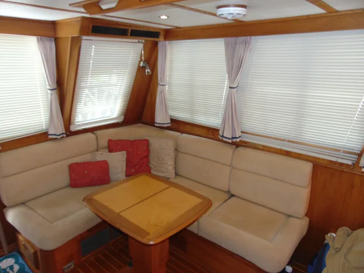 Lady Susan Yacht Photos Pics Interior of 2004 Sabre 36 Flybridge with beige seating and wooden table.