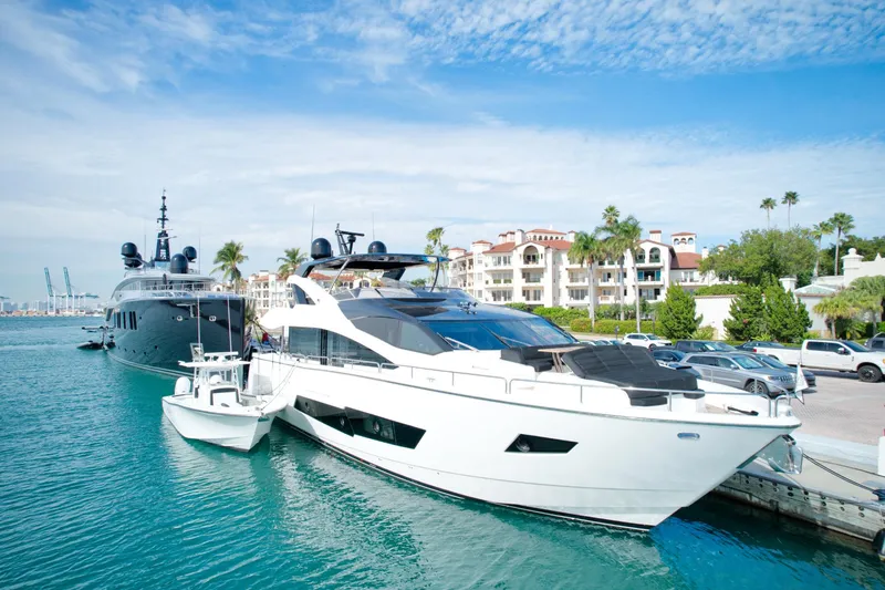 Alexa Yacht Photos Pics 2018 Sunseeker 86 Yacht docked in a marina with luxury buildings in the background.