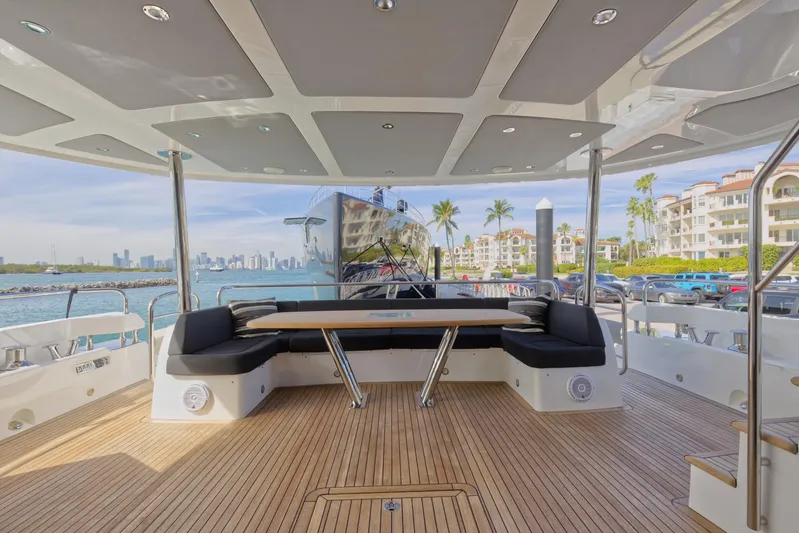 Alexa Yacht Photos Pics Sunseeker 86 Yacht 2018 aft deck with seating area, ocean view, and luxury marina backdrop.