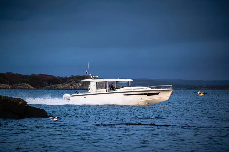  Yacht Photos Pics 2024 Nimbus C-11 boat cruising on a scenic lake.