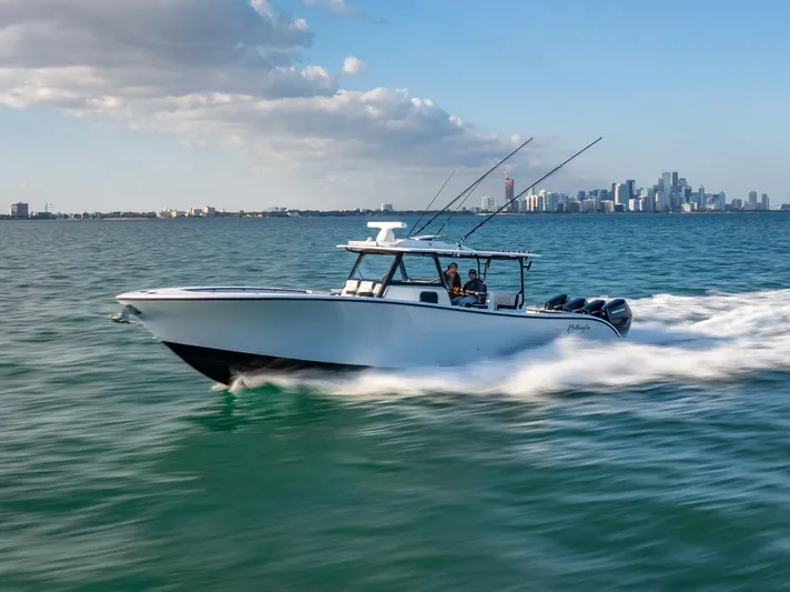  Yacht Photos Pics 2024 Yellowfin 42 boat cruising on open water with city skyline in background.