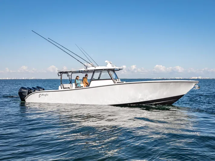  Yacht Photos Pics 2024 Yellowfin 42 boat cruising on open water under clear blue sky.