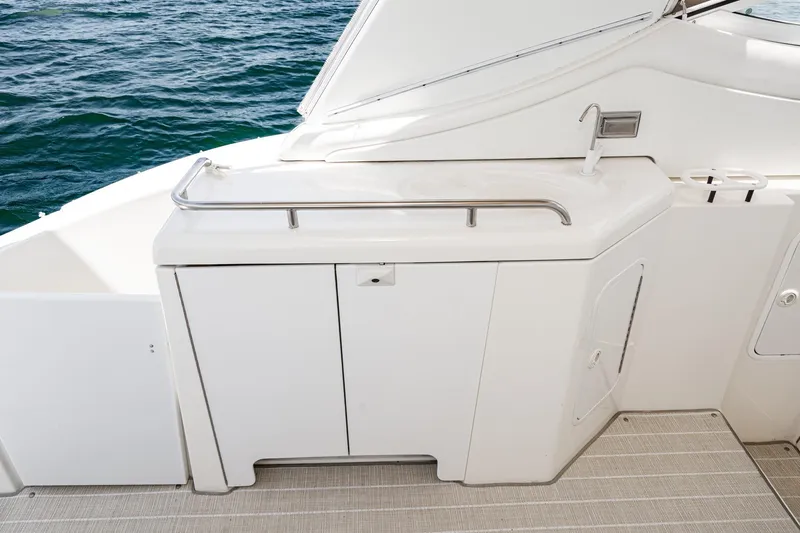 My Jojo Yacht Photos Pics 2005 Cruisers Yachts 370 Express deck with sink and storage, overlooking water.