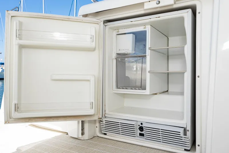 My Jojo Yacht Photos Pics Open refrigerator on 2005 Cruisers Yachts 370 Express, showcasing interior shelves and ice maker.