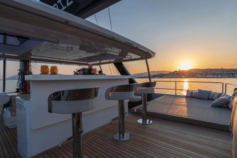 Endless Horizon II Yacht Photos Pics Luxurious Sunreef 80 Sail yacht deck at sunset, featuring bar stools and lounge area.