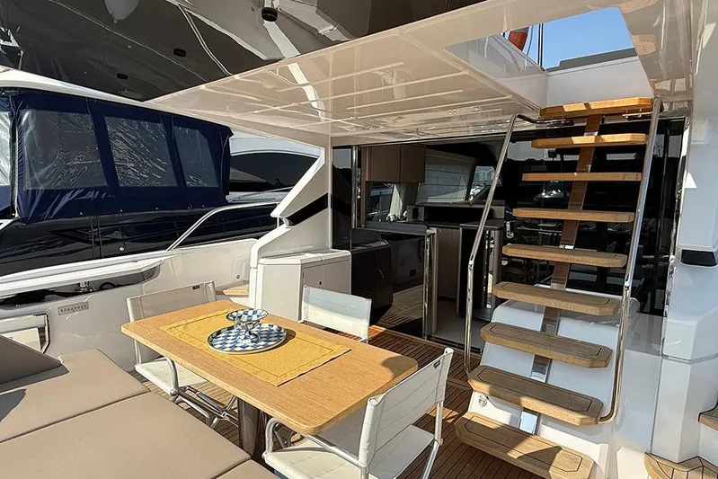 Aslid Yacht Photos Pics Luxurious 2025 Ferretti Yachts 580 interior with elegant dining area and wooden staircase.