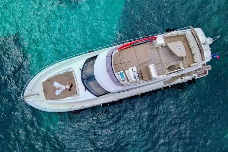  Yacht Photos Pics Aerial view of 2015 Prestige 550 yacht on turquoise water, person relaxing on deck.