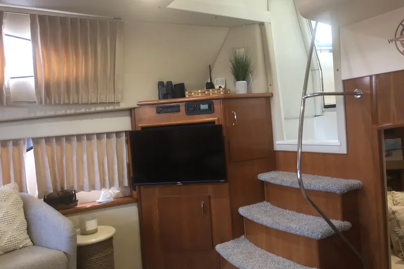 Agape III Yacht Photos Pics Interior of 2005 Carver 41 Cockpit Motor Yacht with TV, stairs, and cozy seating area.