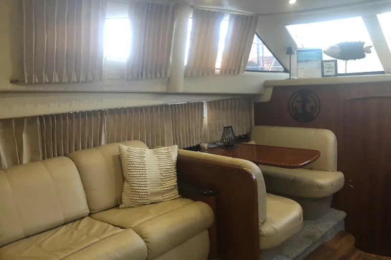 Agape III Yacht Photos Pics Interior of 2005 Carver 41 Cockpit Motor Yacht with beige seating and wooden table.