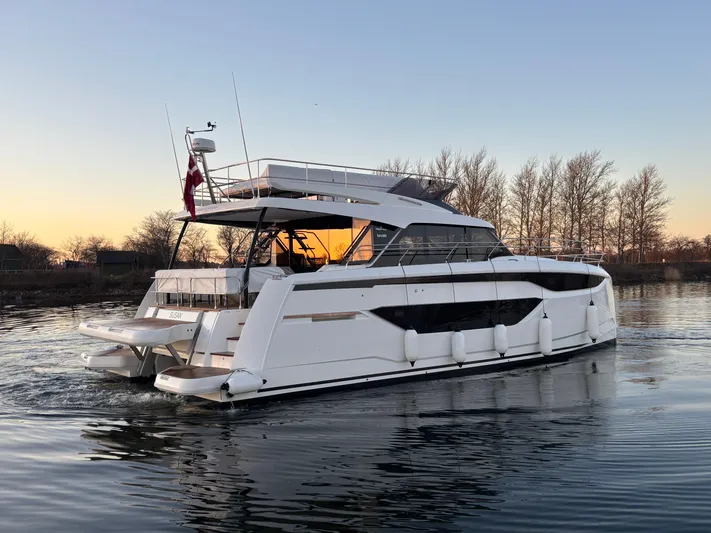  Yacht Photos Pics Luxury 2025 Prestige M48 yacht cruising at sunset on calm waters.