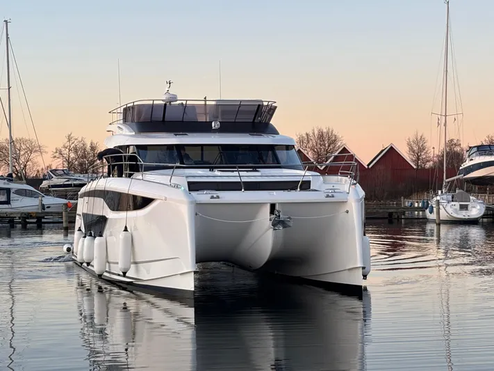  Yacht Photos Pics 2025 Prestige M48 yacht docked at sunset, reflecting on calm water.