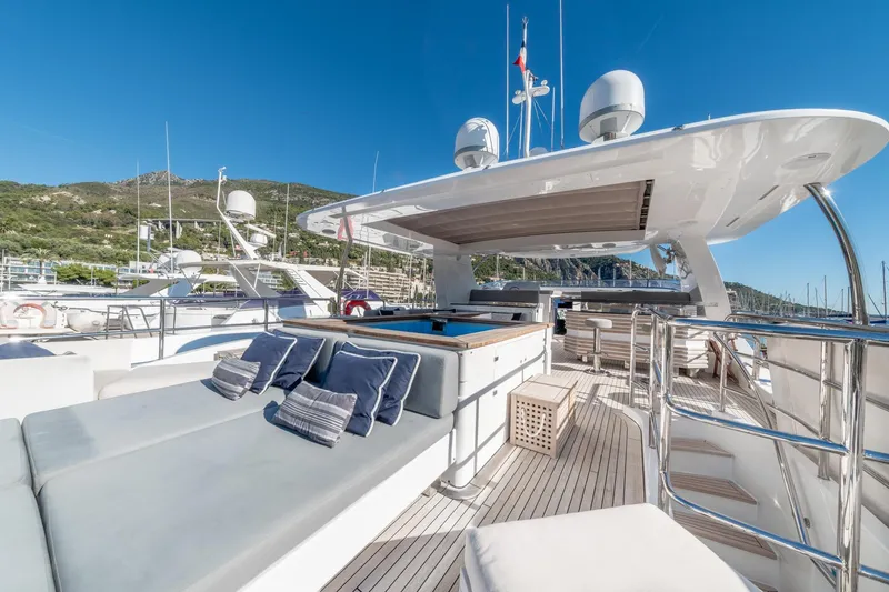  Yacht Photos Pics Luxurious 2013 Benetti Delfino 93 yacht deck with sun loungers and scenic marina view.