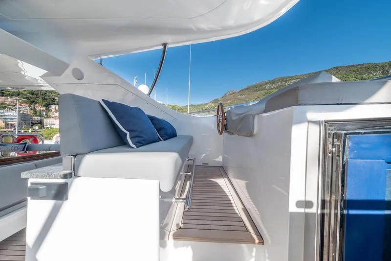  Yacht Photos Pics Luxurious Benetti Delfino 93 yacht deck with cushioned seating, 2013 model, scenic coastal view.