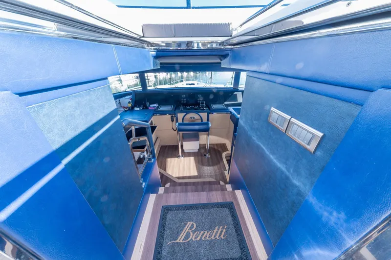  Yacht Photos Pics Pilothouse interior of 2013 Benetti Delfino 93 yacht, featuring blue decor and control panel.